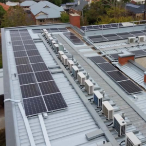 Image of industrial workplace re-roofing job with multiple solar panels