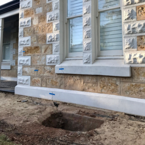 Heritage traditional style home with a hole allowing for underpinning the foundation