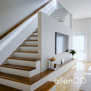 Timber staircase and feature wall for a wall mounted TV in an open plan living room