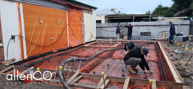 Construction workers preparing the foundation of a home extension