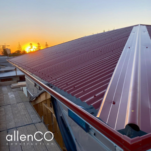 Burgandy corrugated tin roof with a setting sun