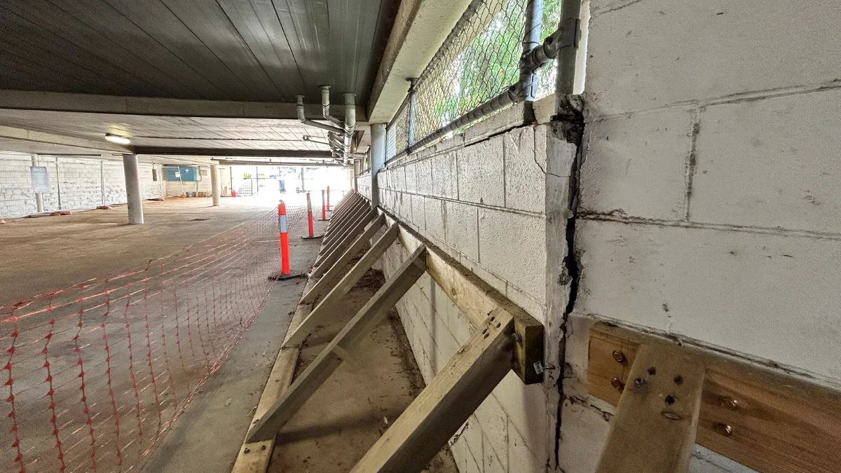 Commercial underpinning work showing the supports of a wall in an underground carpark to stop it from collapsing.